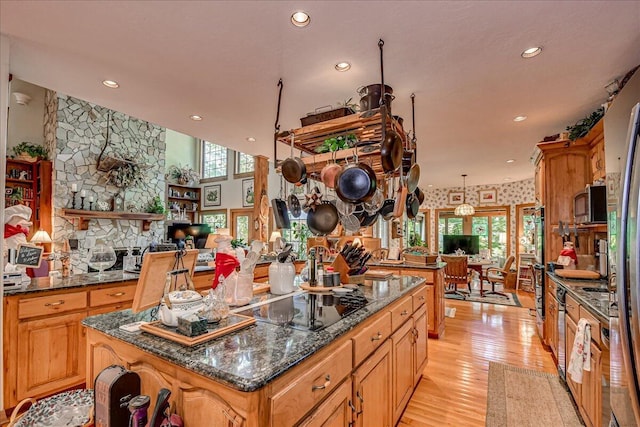 kitchen featuring black electric cooktop, light hardwood / wood-style flooring, plenty of natural light, and a kitchen island