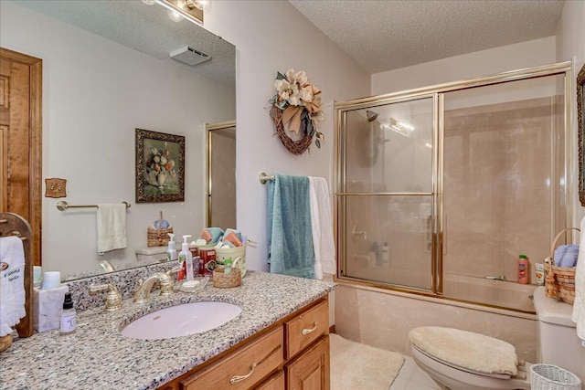 full bathroom featuring combined bath / shower with glass door, tile patterned floors, a textured ceiling, vanity, and toilet