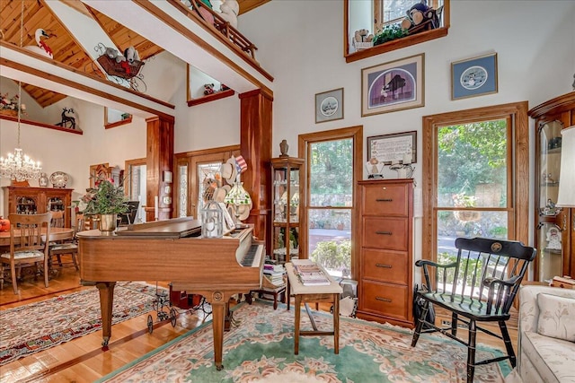 misc room with high vaulted ceiling, a wealth of natural light, and a notable chandelier