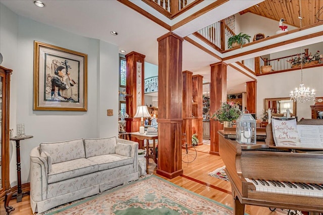 interior space with a towering ceiling, light wood-type flooring, and an inviting chandelier