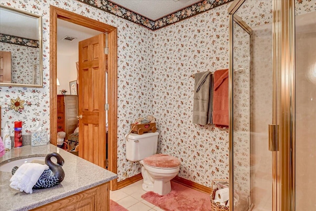 bathroom featuring tile patterned flooring, vanity, toilet, and a shower with shower door