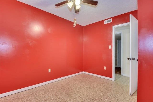 spare room featuring a ceiling fan, baseboards, speckled floor, visible vents, and a textured ceiling