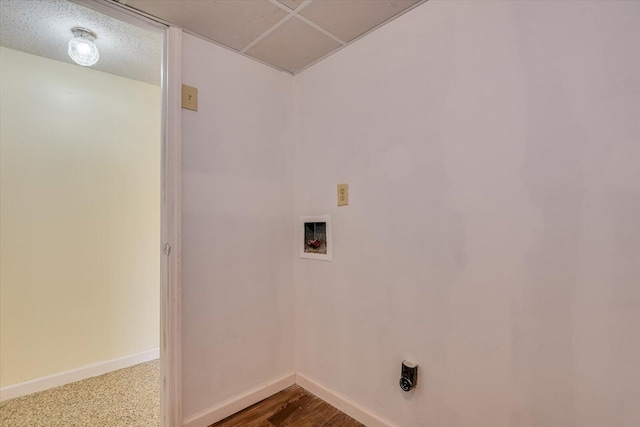 laundry area with baseboards, a textured ceiling, hookup for a washing machine, and laundry area