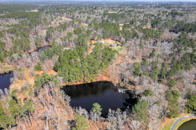 birds eye view of property with a wooded view and a water view