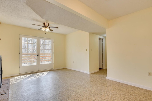 unfurnished room with a ceiling fan, baseboards, speckled floor, french doors, and a textured ceiling