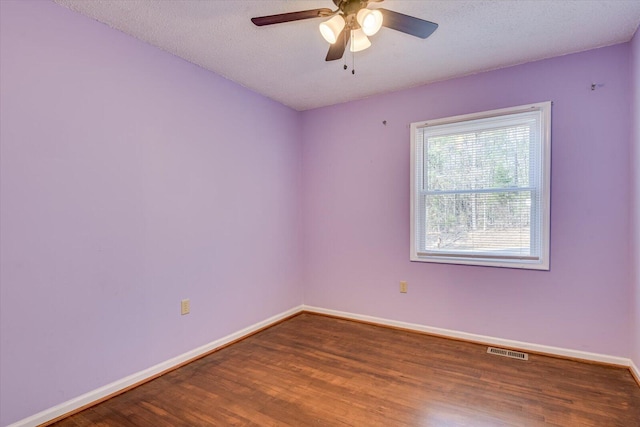 unfurnished room featuring ceiling fan, wood finished floors, visible vents, and baseboards