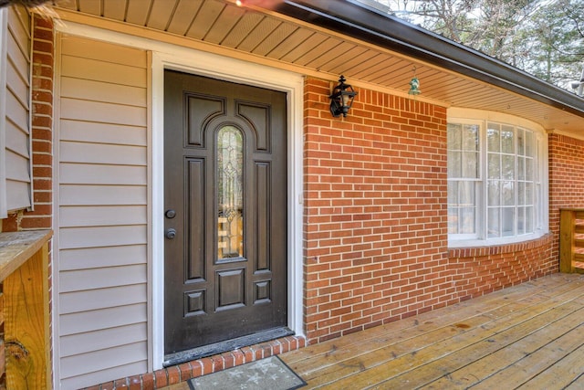 view of exterior entry featuring brick siding