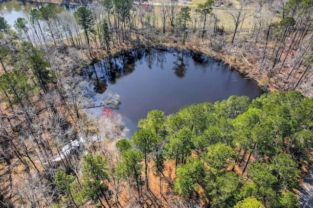 aerial view featuring a wooded view and a water view