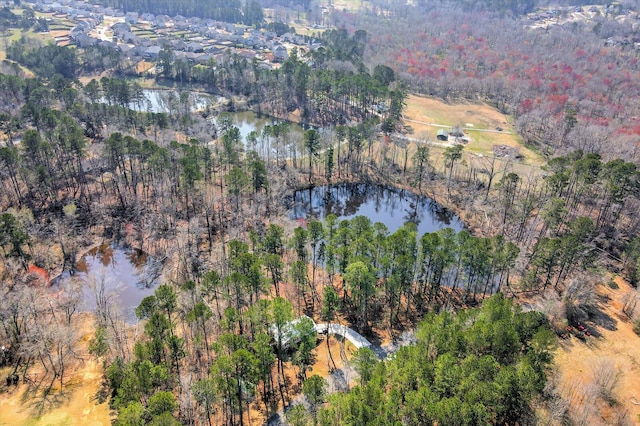 drone / aerial view featuring a wooded view and a water view