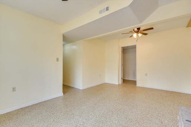 spare room featuring visible vents, light speckled floor, baseboards, and ceiling fan