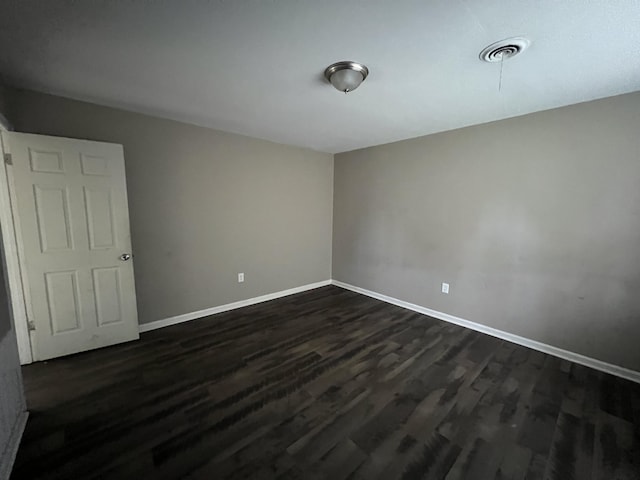 spare room with dark hardwood / wood-style floors