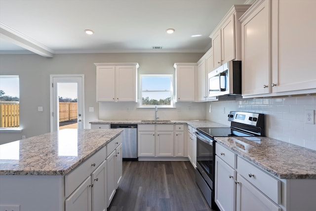 kitchen with dark wood-style floors, appliances with stainless steel finishes, crown molding, white cabinetry, and a sink