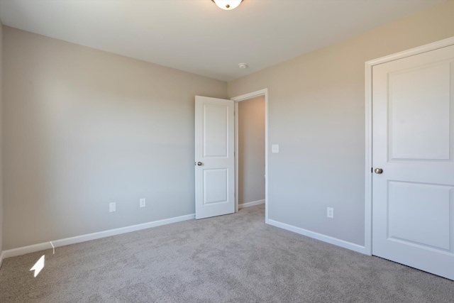 carpeted empty room with baseboards