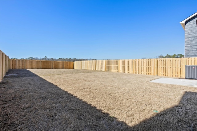 view of yard with central AC unit and a fenced backyard