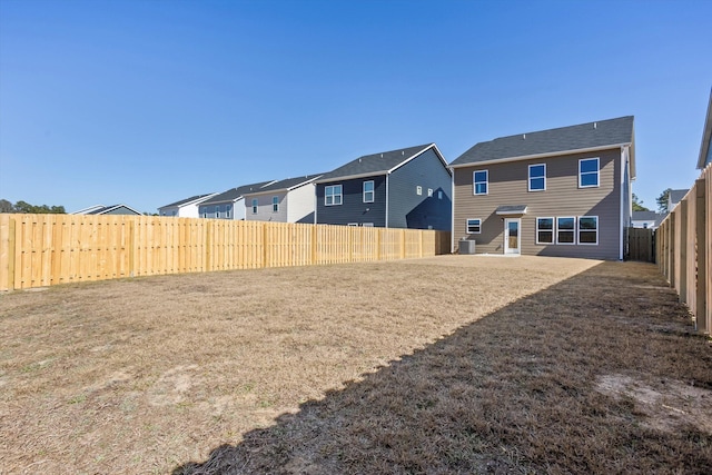 view of yard with a residential view, a fenced backyard, and cooling unit