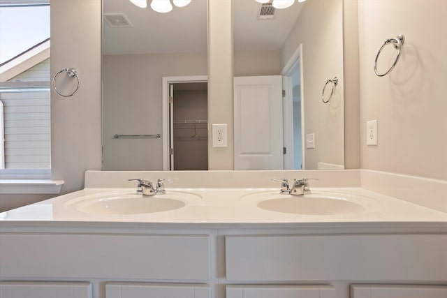 full bath featuring visible vents, a sink, and double vanity