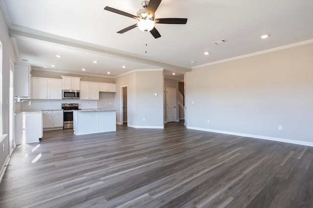 unfurnished living room featuring dark wood-style floors, visible vents, ornamental molding, a sink, and baseboards