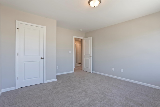 unfurnished bedroom featuring baseboards and light colored carpet