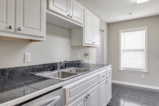 4005 Calypso Dr, Augusta, GA 30909 - kitchen featuring white cabinets, stainless steel dishwasher, dark tile patterned flooring, and a textured ceiling