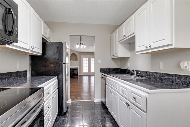 4005 Calypso Dr, Augusta, GA 30909 - kitchen featuring appliances with stainless steel finishes, a textured ceiling, white cabinetry, tile counters, and a chandelier