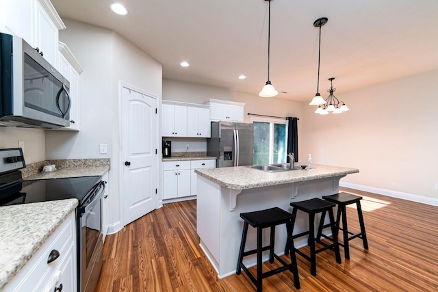 kitchen with a center island with sink, a breakfast bar, white cabinets, and stainless steel appliances