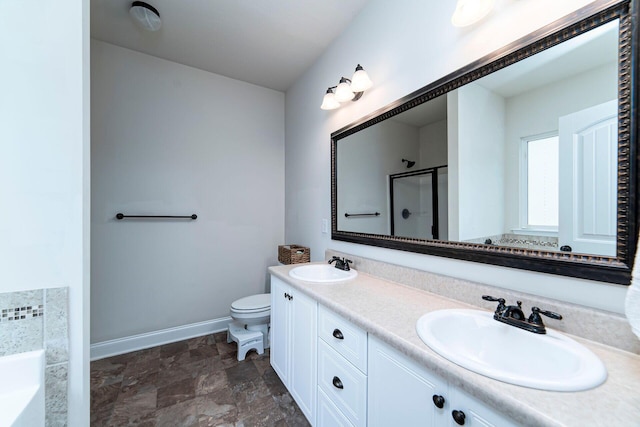 bathroom featuring vanity, a shower with shower door, and toilet