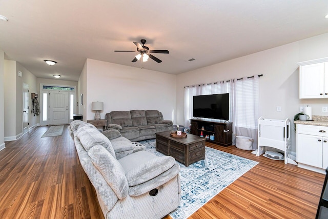 living room with dark hardwood / wood-style floors and ceiling fan