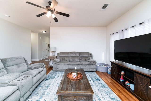 living room featuring wood-type flooring and ceiling fan