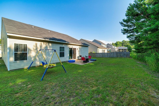 rear view of property with a yard, a playground, and a patio