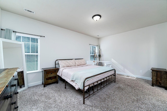 carpeted bedroom featuring multiple windows