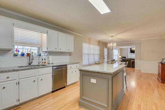 kitchen with dishwasher, an inviting chandelier, light wood finished floors, and a sink