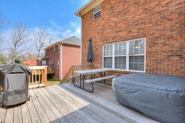 wooden terrace featuring outdoor dining space and area for grilling