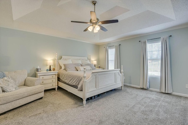 carpeted bedroom with a raised ceiling, crown molding, baseboards, and a textured ceiling