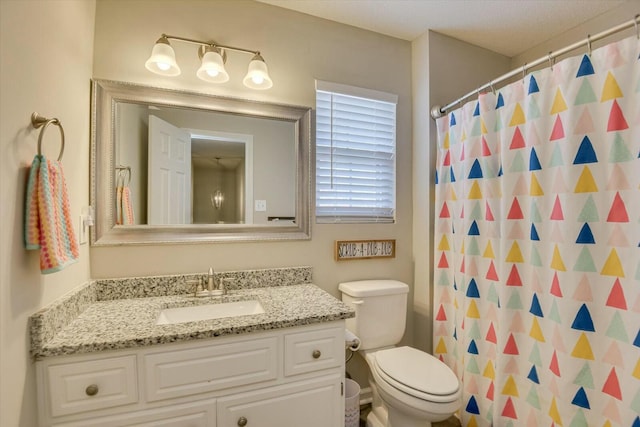 bathroom with a shower with curtain, toilet, and vanity