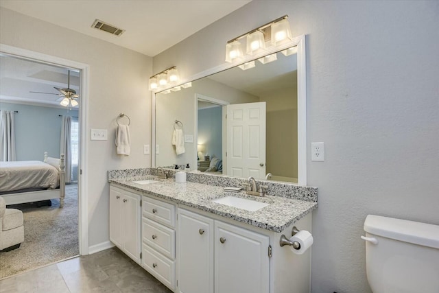 ensuite bathroom with visible vents, connected bathroom, toilet, and a sink