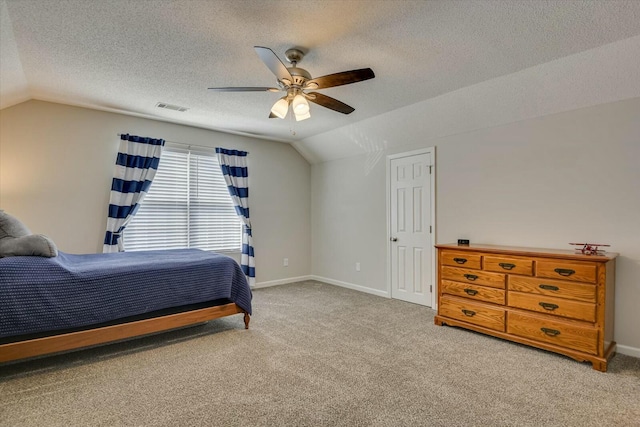 carpeted bedroom featuring visible vents, baseboards, a ceiling fan, and vaulted ceiling