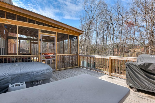 wooden deck with grilling area and a sunroom