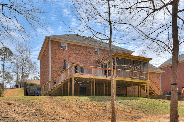 back of house featuring stairway, brick siding, a wooden deck, and a sunroom