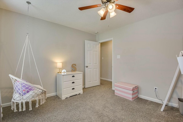 interior space with baseboards, carpet, and a ceiling fan