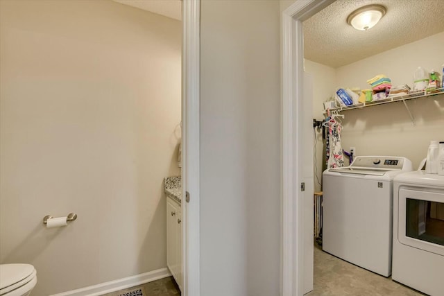 laundry room featuring washer and dryer, laundry area, baseboards, and a textured ceiling