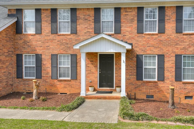 view of front of home with crawl space and brick siding