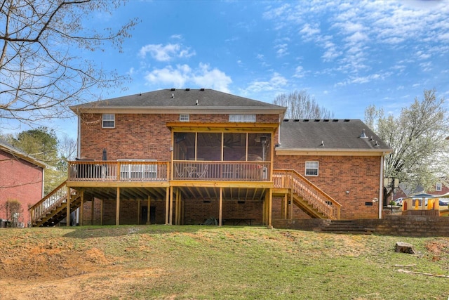 back of property featuring stairway, brick siding, a yard, and a sunroom