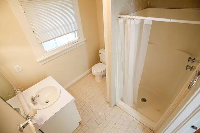 bathroom with a shower with shower curtain, vanity, and toilet