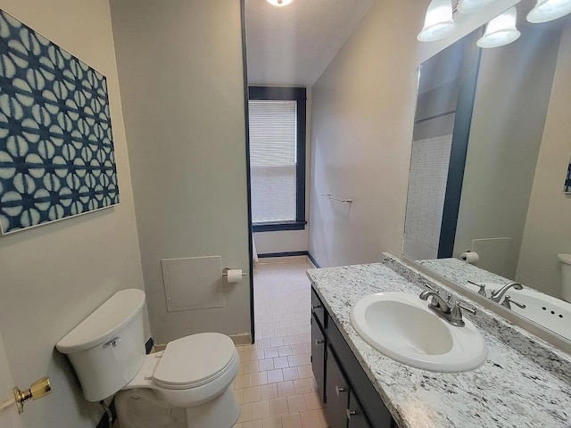 bathroom featuring toilet, vanity, and tile patterned floors