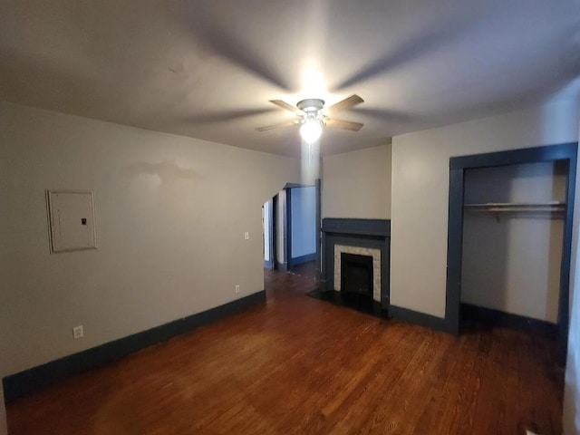 unfurnished living room featuring ceiling fan, dark hardwood / wood-style floors, and electric panel