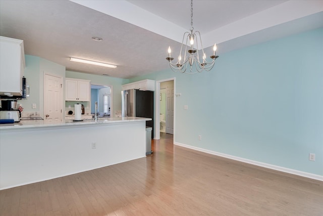 109 Mitchell Dr, North Augusta, SC 29860 - kitchen with light wood finished floors, light countertops, white cabinets, a peninsula, and a chandelier