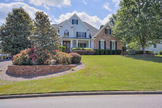 view of front facade with a front lawn and brick siding