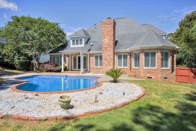 back of house with brick siding, a chimney, an outdoor pool, crawl space, and a patio
