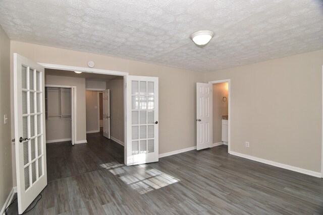 unfurnished room featuring dark hardwood / wood-style flooring and a textured ceiling