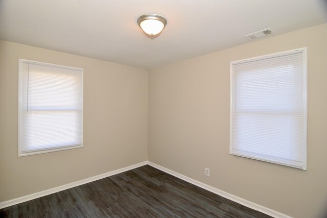 empty room with dark hardwood / wood-style flooring